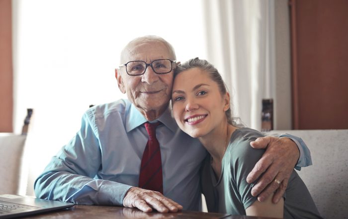 Senior man smiles as he hugs his daughter