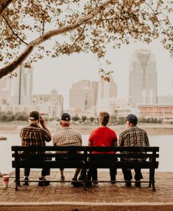 old people sitting in a group looking happy on a bench busting the myth older people are lonely
