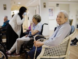 a senior woman smiling while sitting in a wheelchair