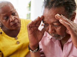 A senior woman comforting her husband who is distressed by senior moments and signs of dementia