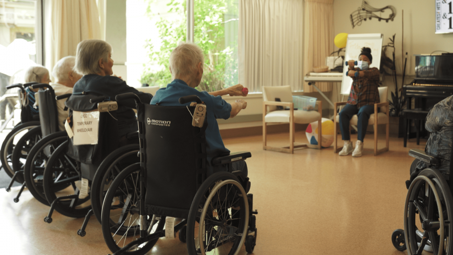 Nurse helps elderly people exercise at care lynn valley care centre 