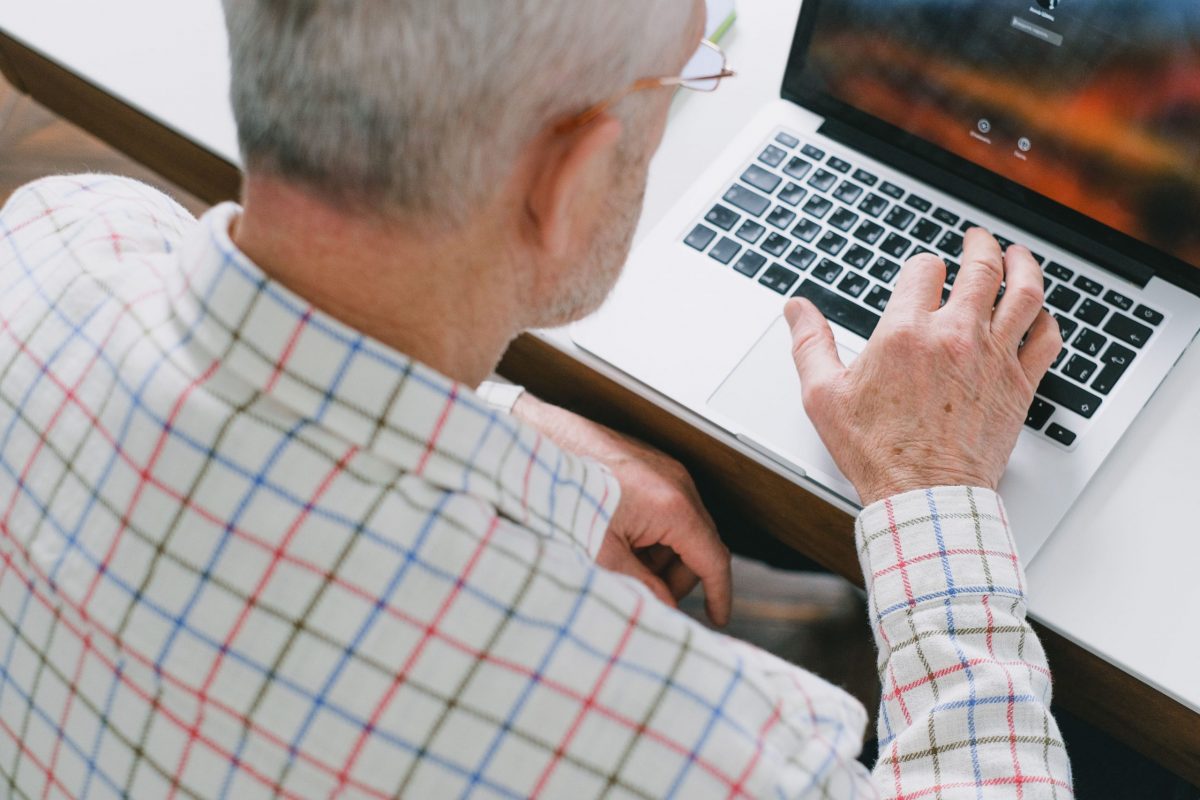 elderly man using laptop researching common scams for seniors