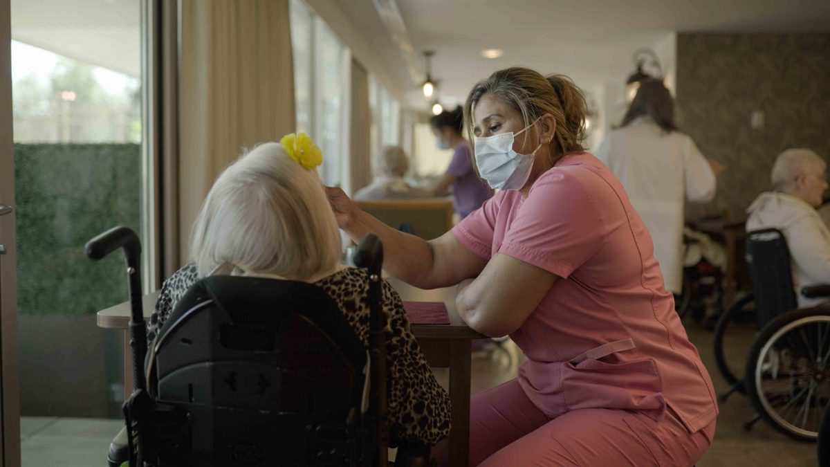 nurse helping elderly woman at lynn valley care centre