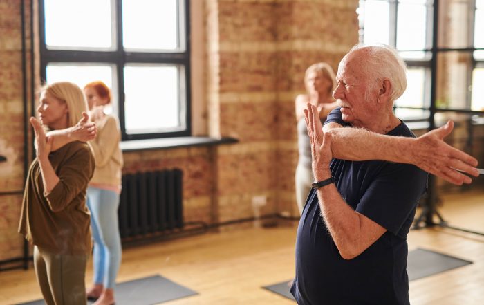 elderly man doing yoga practicing self care for seniors