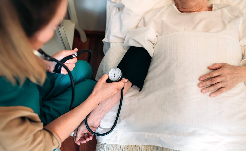 senior healthcare worker checking blood pressure of a senior woman at care home in vancouver