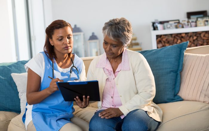indian female doctor clipboard explaining medication to senior patient