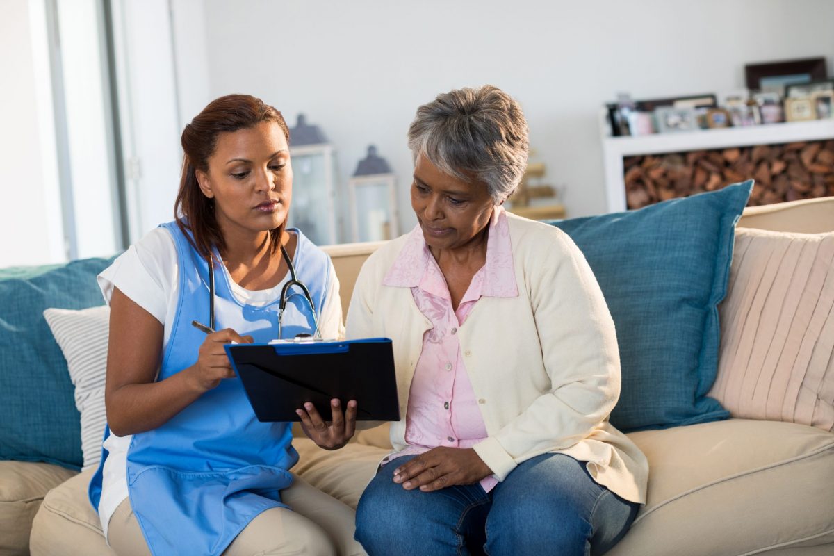 indian female doctor clipboard explaining medication to senior patient