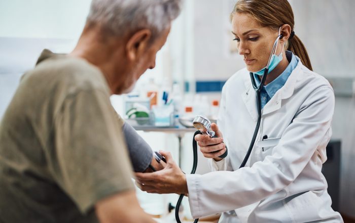 female geriatrician checking blood pressure of senior man