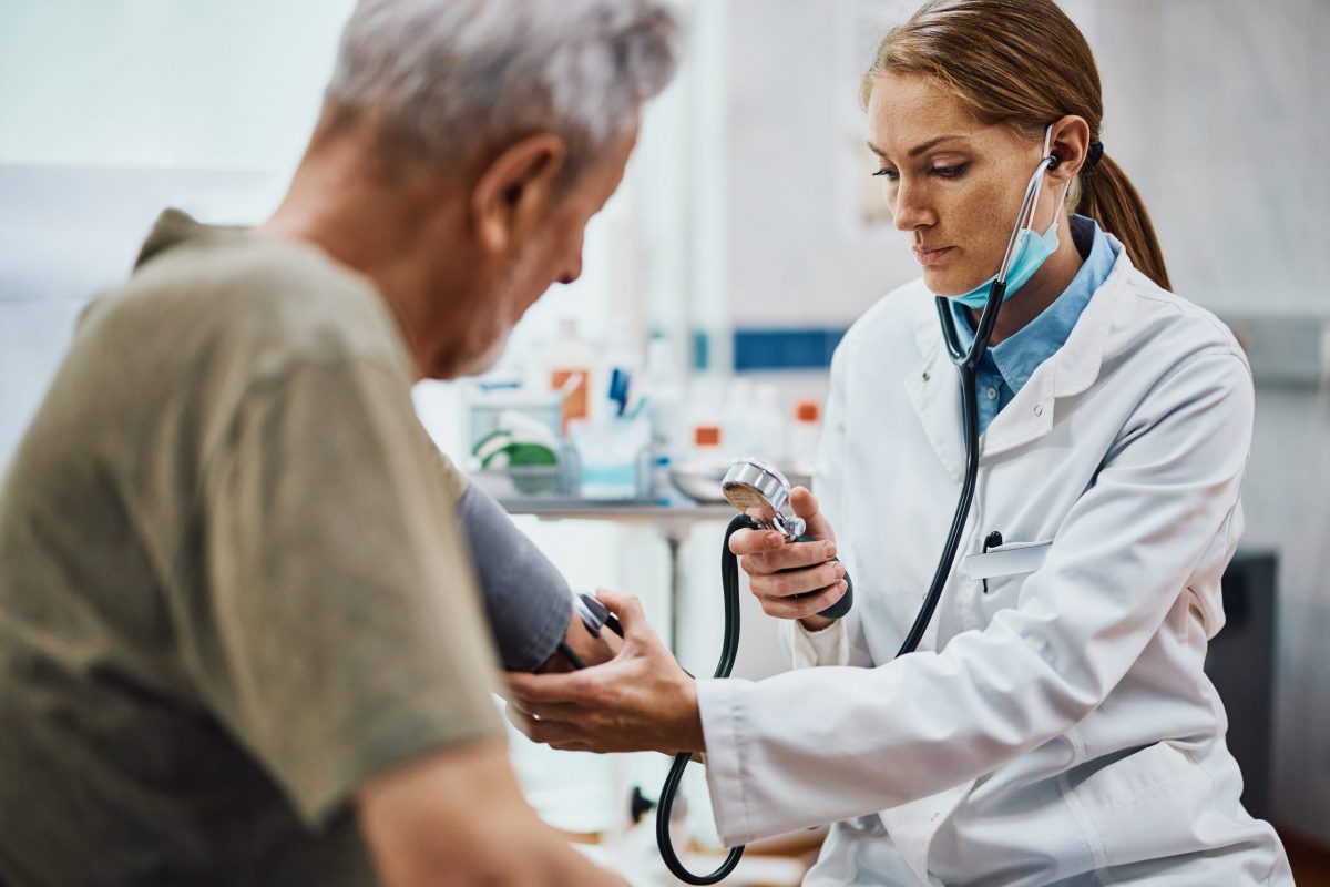 female geriatrician checking blood pressure of senior man
