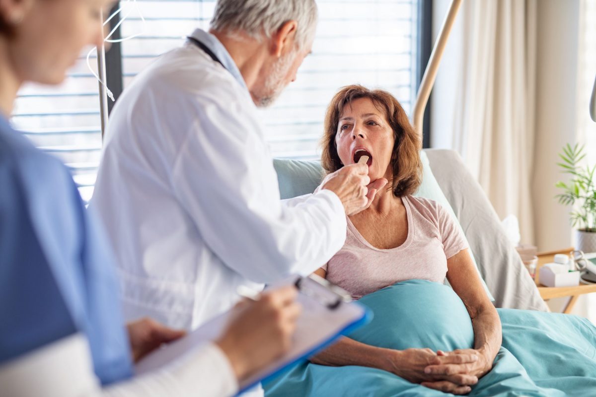Gerontologist helping senior woman at a hospice