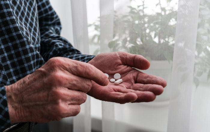 Senior mans hand with vitamin pills