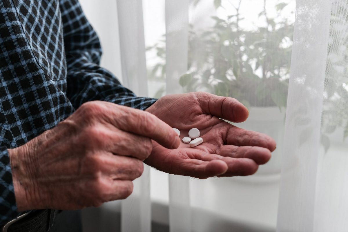 Senior mans hand with vitamin pills