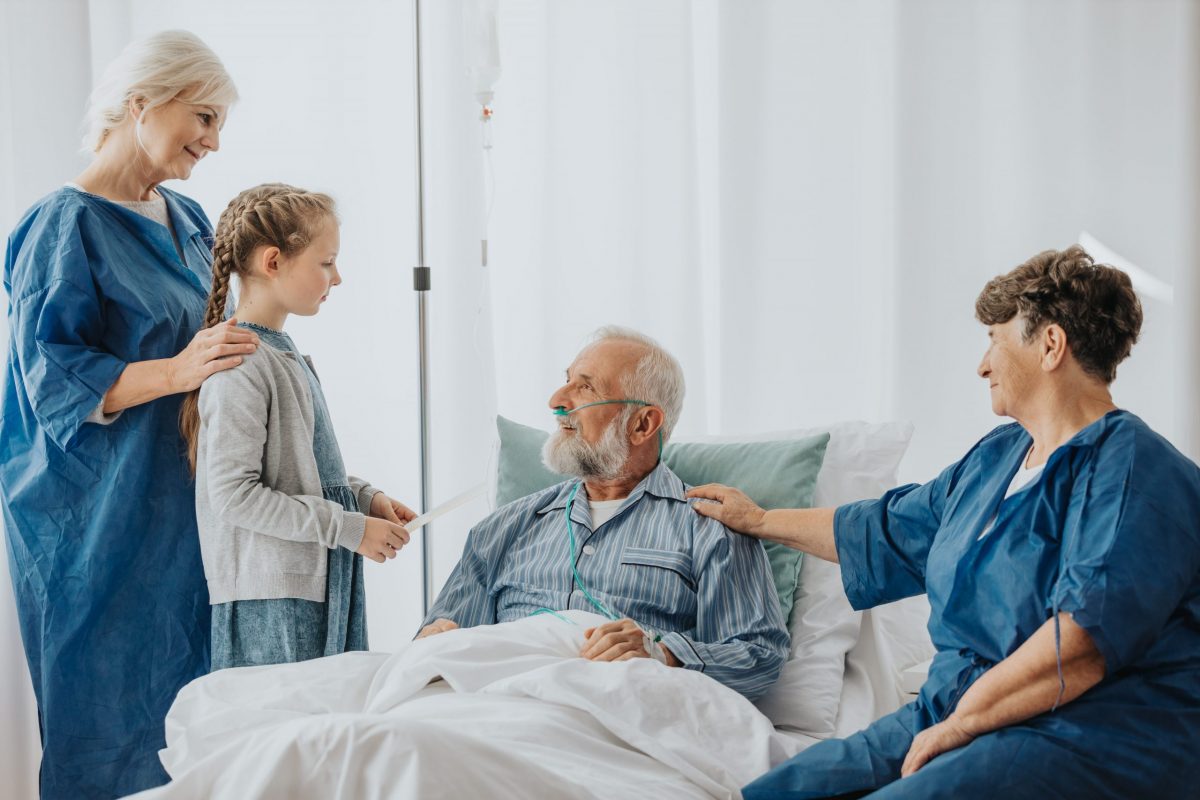 Loving family spending time together with sick grandfather in the hospital