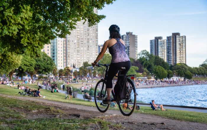 Adventurous White Caucasian Adult Woman riding a road bicycle in Stanley Park. A Fun Attractions in Vancouver BC.